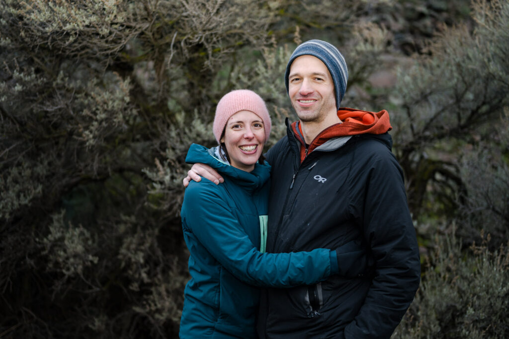 Portrait photograph of a couple in front of Sage bushes.