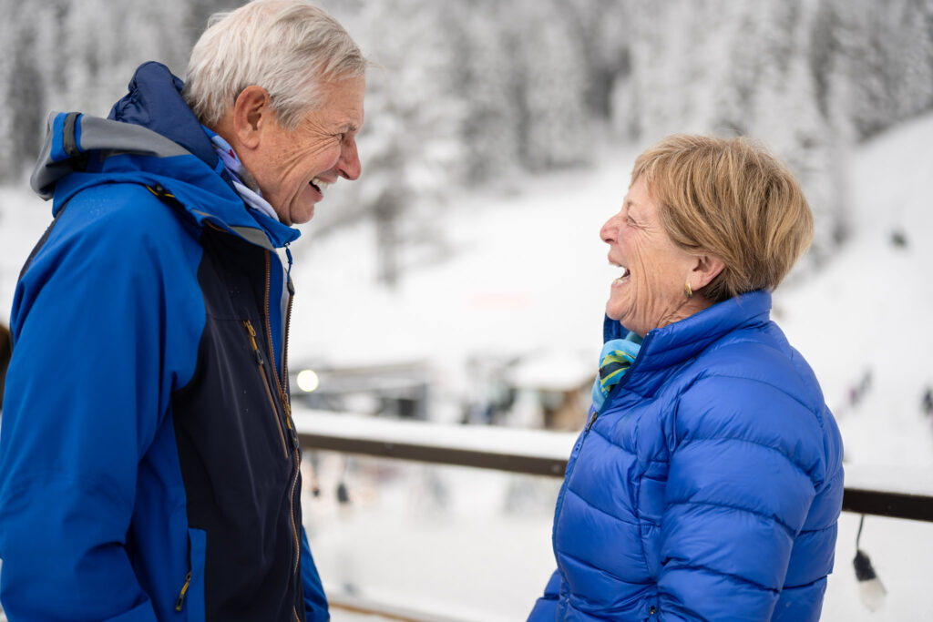 Photograph of an older couple laughing at a mutual joke.